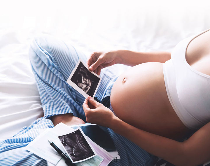 Photo of a pregnant woman admiring her baby in ultrasound images